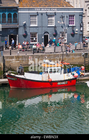 Il Royal Oak pub con barca da pesca a Weymouth Harbour in giugno Foto Stock