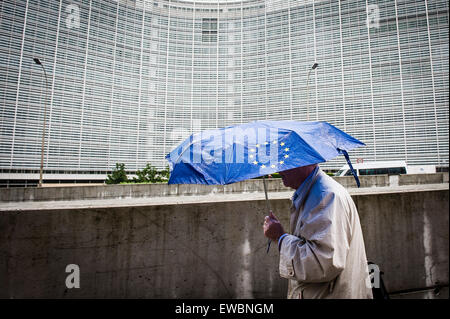 Bruxelles, Belgio. Il 22 giugno, 2015. Pedone sotto ombrellone con la bandiera dell'Unione europea sta camminando lungo la Commissione europea ha sede a Bruxelles in Belgio su 22.06.2015 Capi di stato della zona euro sarà geather per vertice di emergenza sul debito greco oggi in sede UE Credito: dpa picture alliance/Alamy Live News Foto Stock