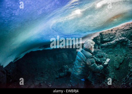 Uno scienziato funziona all'interno di una grotta di vapore sul Monte Erebus, Antartide. Foto Stock