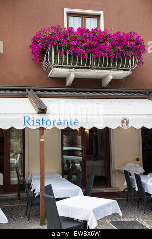 Ristorante italiano tipico con balcone gerani fiori viola Foto Stock