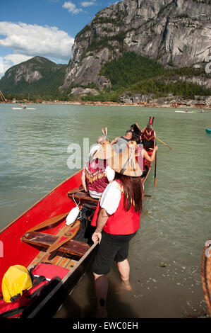 Squamish nazione dei rematori lanciare una tradizionale nativa la guerra in canoa lungo la Squamish waterfront. Squamish BC, Canada. Foto Stock