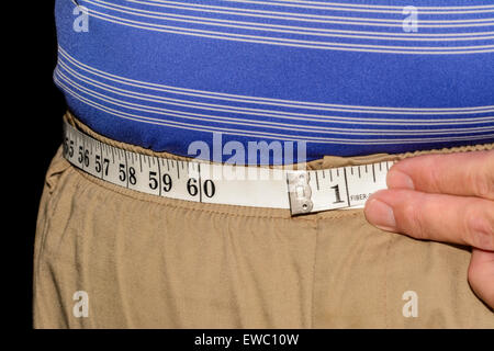 Uomo obesi misurando la sua vita con un nastro di misurazione. Foto Stock