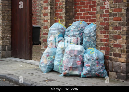 Pila del cestino pieno di sacchetti per la raccolta separata di metallo lattine per bibite e la bottiglia di plastica garbage in Belgio Foto Stock