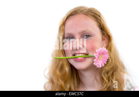 Caucasian ragazza adolescente con fiore rosa in bocca isolato grigio su sfondo bianco Foto Stock