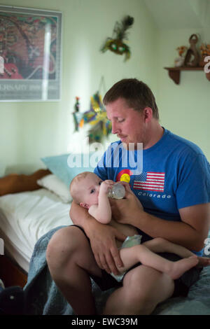 Detroit, Michigan - Adam Hjermstad alimenta il latte per il suo 11-mese-vecchio figlio Adam Hjermstad Jr. Foto Stock