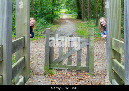 Caucasico due ragazze adolescenti nascondersi in entrata in legno del sentiero escursionistico nella natura Foto Stock