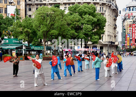 Cina, Shanghai, Nanjing Road, tai chi, esercizi di persone prima di aprire i negozi. La mattina presto il tai chi e il gruppo di ballerini che esercitano su Nanjing cinese Cina Foto Stock