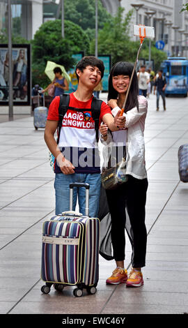 Stick selfie foto attraente bella giovani visitatori a Nanjing Road. Strada principale per lo shopping di Shanghai. Cina Foto Stock