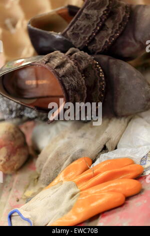 Donna di scarpe e guanti di gomma prevista su una fase di stallo in un mercato di area inferiore della città. Gyantse città e contea-Shigatse pref.-Tibet. Foto Stock