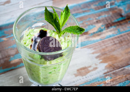 Un sano frullato vegetale frullato realizzato da miscelato, yogurt ghiacciato, menta e piselli. Condito con un po' di cioccolato e menta fresca. Foto Stock