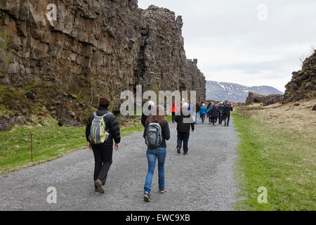 I turisti a piedi attraverso il Almannagja linea anomalia nel mid-atlantic ridge Nord America placca Thingvellir parco nazionale di Islanda Foto Stock