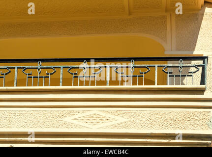 Frammento di una facciata della vecchia casa sulla costa dell'isola di Creta con un balcone e antico recinto , forgiato in metallo. Foto Stock