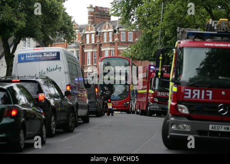 Londra, Regno Unito. Il 23 giugno, 2015. Un northbound 134 bus è bloccato dal traffico pesante e veicoli di emergenza presso la scena - secondo una Londra Vigili del Fuoco comunicato stampa, 72 vigili del fuoco sono stati coinvolti nella lotta contro un incendio a tre piani di indirizzo su Wood Lane in Highgate. Servizi di emergenza sono ancora sulla scena, secondo come riferito spegnimento braci presso l'albergo, che si trova in una zona densamente boscosa. Credito: Finn Nocher/Alamy Live News Foto Stock