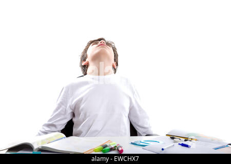 Liscia caucasico-pelato ragazzo seduto mentre si fanno i compiti a braccia aperte guardando il cielo con la sua testa indietro Foto Stock