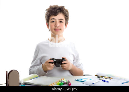 Felice liscia caucasico-pelato boy nel manicotto corto t-shirt gioca con un controller di gioco seduti di fronte la sua casa sulla scrivania Foto Stock