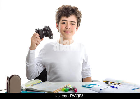 Felice liscia caucasico-pelato boy nel manicotto corto t-shirt gioca con un controller di gioco seduti di fronte la sua casa sulla scrivania Foto Stock