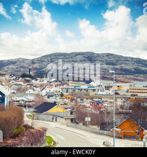 Rorvik, cittadina norvegese con coloratissime case di legno sulle colline rocciose sotto il luminoso cielo nuvoloso Foto Stock