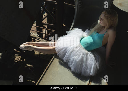 Ballerina seduta sul bordo del ponte Foto Stock