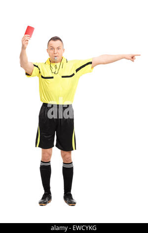 A piena lunghezza Ritratto di un arrabbiato arbitro di calcio che mostra un cartellino rosso e dispositivo di puntamento con la sua mano isolati su sfondo bianco Foto Stock