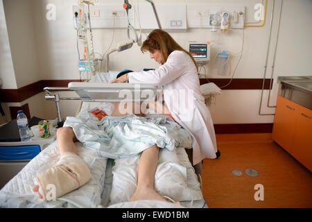 Medico accanto al giovane paziente nel letto di ospedale pediatrico ward Foto Stock