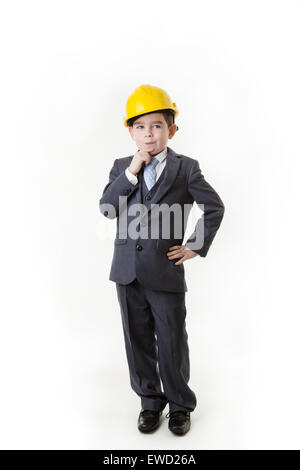 Ragazzo giovane fingendo lui è un architetto che indossa un elmetto di pensare a se stesso Foto Stock