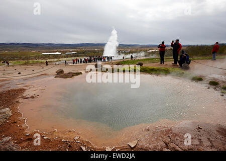 Guardando al di sopra del grande geysir di strokkur geyser che erutta a geyser sito geotermico Geysir Islanda Foto Stock