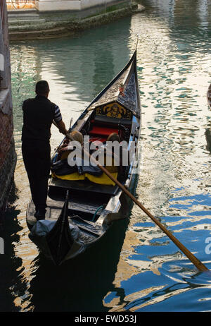 Guidare una Gondola attraverso la rete dei canali di Venezia Foto Stock