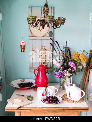 Lampadario bordato sopra un piccolo tavolo prevista con picnic estivo e fiori selvatici Foto Stock