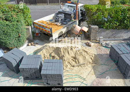 Miglioramento di casa giardino frontale di immobili residenziali la creazione di una nuova auto vialetto dopo la rimozione della vecchia lastra di calcestruzzo sabbia e blocco di pavimentazione materiali REGNO UNITO Foto Stock