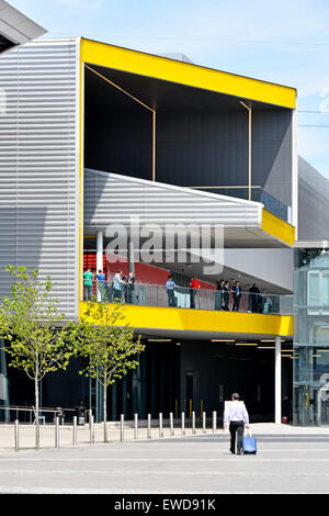 Business uomo a camminare verso la sala delle esposizioni ingresso orientale di Londra Excel Centre in East London Docklands Newham Regno Unito Inghilterra Foto Stock