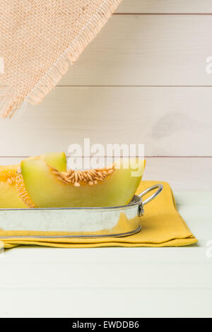 Succosa di melone Honeydew su una tavola di legno dello sfondo. Foto Stock