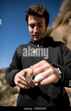 Italian alpinista professionista Stefano Ghisolfi taping le dita prima di rendere il quarto di arrampicata Demencia Senil 9a+ in Foto Stock