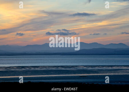 Tramonto in Morecambe Bay guardando verso il Lake District Fells Foto Stock