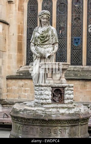 Statua di una donna con una brocca accanto a una fontana di Abbazia di Bath in bagno con lo slogan "l'acqua è meglio' Foto Stock