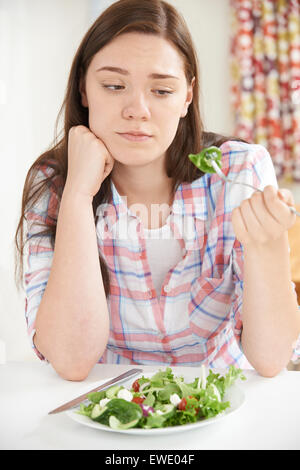 Ragazza adolescente sulla dieta mangiare piatto di insalata Foto Stock