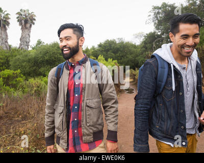 Due sorridenti giovani uomini a camminare in un parco Foto Stock