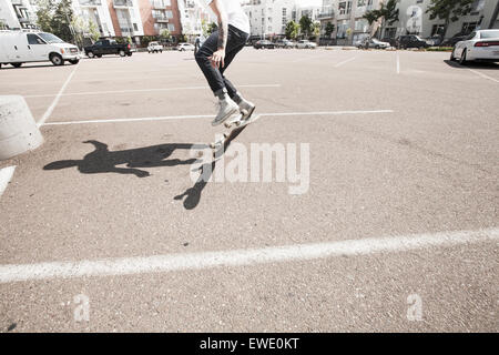 Giovane uomo lo skateboard in un parcheggio Foto Stock