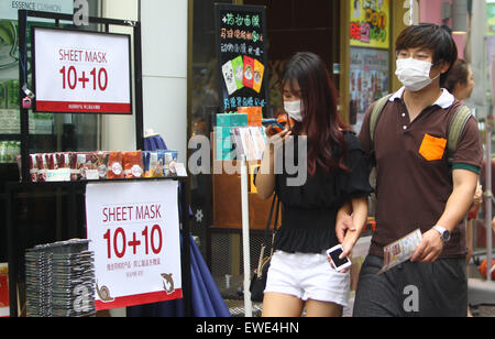 Seoul, Corea del Sud. Il 24 giugno 2015. I turisti a piedi in a Myeongdong quartiere commerciale di Seoul, Corea del Sud, il 24 giugno 2015. Un Cinese paziente di sesso femminile, che è stato infettato con meri in Corea del Sud, recuperato e dimesso dall'ospedale il 22 giugno l'ambasciata cinese a Corea del Sud detto mercoledì. Credito: Yao Qilin/Xinhua/Alamy Live News Foto Stock