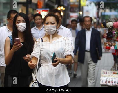 Seoul, Corea del Sud. Il 24 giugno 2015. I turisti a piedi in a Myeongdong quartiere commerciale di Seoul, Corea del Sud, il 24 giugno 2015. Un Cinese paziente di sesso femminile, che è stato infettato con meri in Corea del Sud, recuperato e dimesso dall'ospedale il 22 giugno l'ambasciata cinese a Corea del Sud detto mercoledì. Credito: Yao Qilin/Xinhua/Alamy Live News Foto Stock