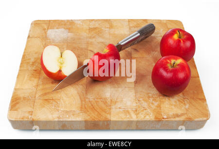 Il taglio della lama un apple sul tagliere con due mele intere sul lato. Foto Stock