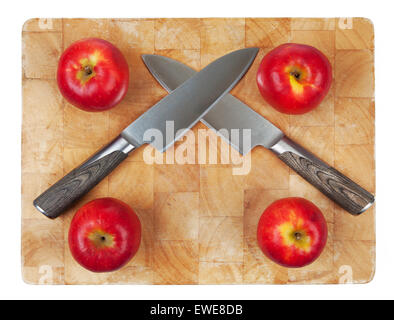 Due lame incrociate sul tagliere con quattro mele. Foto Stock