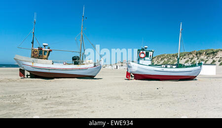 Danese di piccole barche da pesca spiaggiata a Loekken nel Nord dello Jutland con dune di sabbia e spiaggia di capanne in background Foto Stock