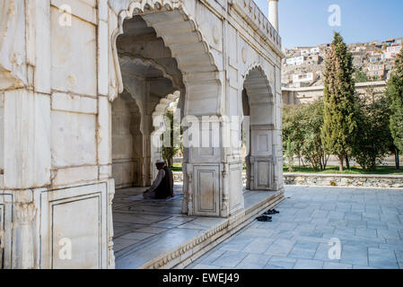 Uomo che prega in piccoli di marmo bianco della Moschea Shah Jahan all'interno del Babur's garden, Kabul, Afghanistan Foto Stock