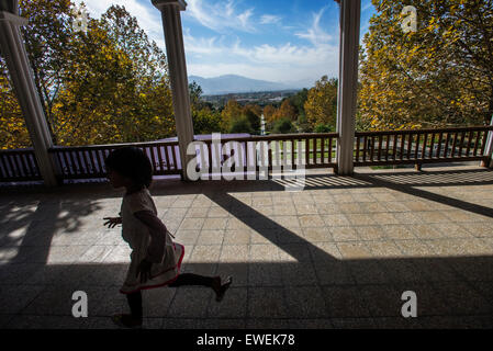 Bambina corre attraverso il vestibolo del Portico Pavilion all'interno del Babur's garden, Kabul, Afghanistan Foto Stock