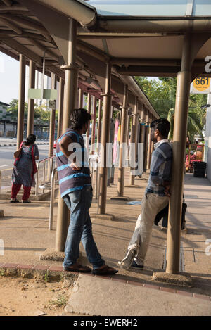 I lavoratori migranti in fermata bus in Little India, Singapore Foto Stock