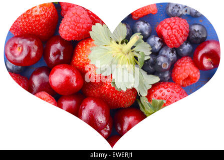 Frutta estiva, fragole, ciliegie, mirtilli e lamponi, sul blu scuro legno rustico tavolo in sagoma ritagliata forma di cuore Foto Stock