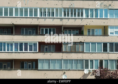 La facciata di un edificio con segni di colpi di arma da fuoco sui muri di Sarajevo Foto Stock