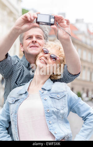 Felice di mezza età giovane tenendo ritratto di auto all'aperto Foto Stock