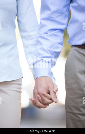 Sezione mediana di mezza età giovane tenendo le mani all'aperto Foto Stock