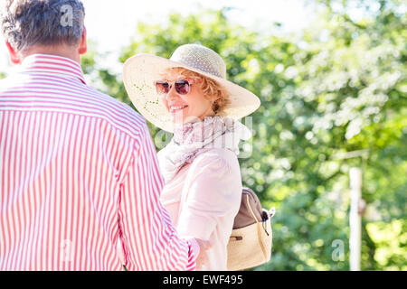 Felice donna di mezza età con uomo in posizione di parcheggio Foto Stock